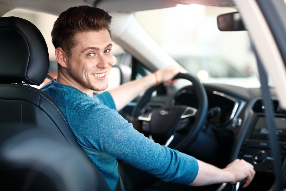 Young Man Sitting Inside Of A Rental Car