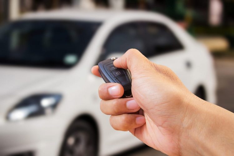 A Hand Holds A Rental Car Key