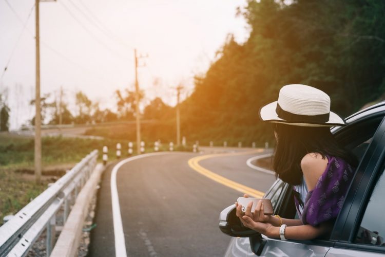 Woman In Hat Sitting In Rental Car On Road